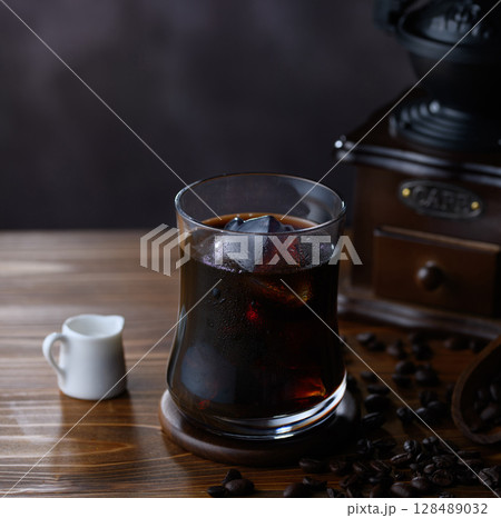 珈琲豆とクラシックミル、氷が輝くアイスコーヒー 珈琲豆とクラシックミル、氷が輝くアイスコーヒー 128489032
