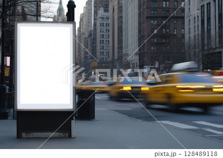 Blank white digital billboard on the blurred day city background. Bus stop with vertical format empty banner. Light Poster. Pylon mockup. Outdoor advertising. Electronic screen in the street 128489118