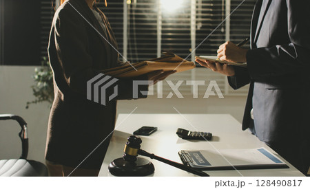 Lawyer explained to the client about the law that must be brought against the court case. Lawyer explained to the client about the law that must be brought against the court case. 128490817