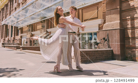 Urban romance. Couple embracing on sunlit urban street with historic architecture 128491499