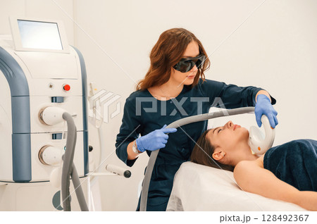 Woman is getting LPG hardware massage in beauty salon. Getting photo rejuvenation procedure at cosmetology clinic Woman is getting LPG hardware massage in beauty salon. Getting photo rejuvenation procedure at cosmetology clinic 128492367