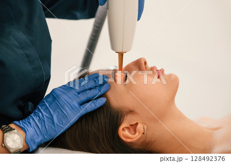 Conception of beauty. Getting photo rejuvenation procedure at cosmetology clinic 128492376