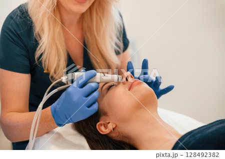 Procedure on the face. Getting photo rejuvenation at cosmetology clinic. Women in beauty salon Procedure on the face. Getting photo rejuvenation at cosmetology clinic. Women in beauty salon 128492382