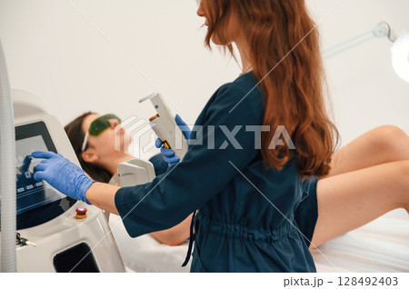 Preparing for photo rejuvenation procedure at cosmetology clinic. Women in beauty salon 128492403