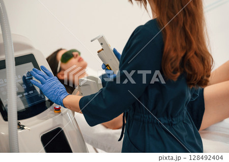 Preparing for photo rejuvenation procedure at cosmetology clinic. Women in beauty salon 128492404