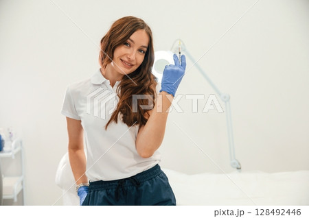 Cosmetologist holding syringe for injection lips augmentation. Women's cosmetology in the beauty salon 128492446