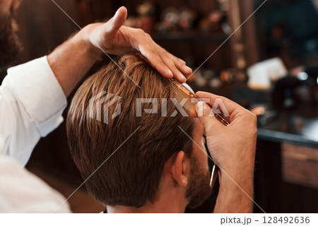 Getting haircut. Man is visiting modern barber shop. Modern style 128492636