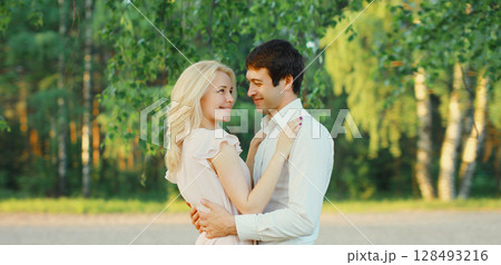 Portrait of beautiful happy smiling young couple in love together hugging in summer park 128493216