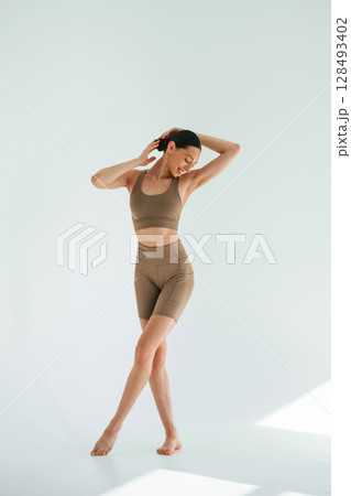 Khaki clothes. Young woman with slim body type is in the studio Khaki clothes. Young woman with slim body type is in the studio 128493402