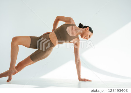 Khaki clothes. Young woman with slim body type is in the studio 128493408