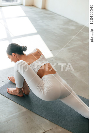 Doing fitness exercises. Young woman with slim body type is in the studio Doing fitness exercises. Young woman with slim body type is in the studio 128493549