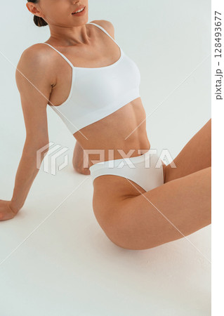 Young woman with slim body type is in fitness clothes in the studio Young woman with slim body type is in fitness clothes in the studio 128493677