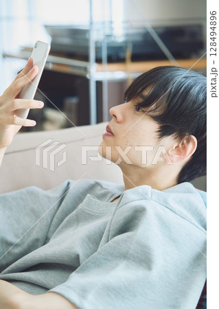 リビングでスマホを見る男性 リビングでスマホを見る男性 128494896