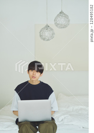 ベッドでパソコンをする男性 128495182