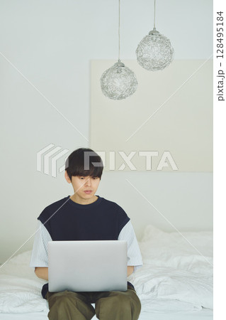 ベッドでパソコンをする男性 128495184