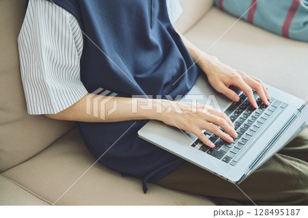 リビングでパソコンをする男性の手元 128495187