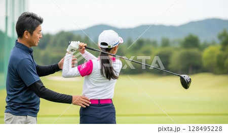 ゴルフのスイングフォームを父親に指導される少女 128495228