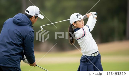 マンツーマンレッスンで美しいスイングを学ぶ少女 マンツーマンレッスンで美しいスイングを学ぶ少女 128495229