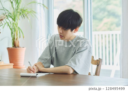 ダイニングでメモをする男性 128495499