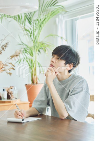 ダイニングでメモをする男性 128495501