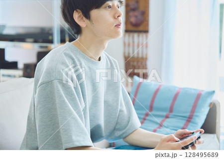 リビングでゲームをする男性 128495689