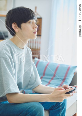 リビングでゲームをする男性 128495690
