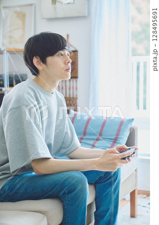 リビングでゲームをする男性 128495691