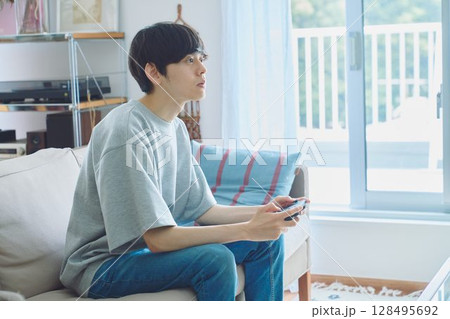 リビングでゲームをする男性 128495692