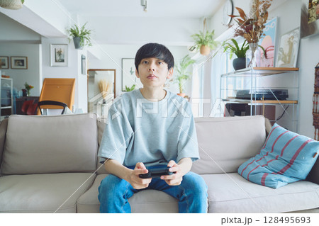 リビングでゲームをする男性 128495693