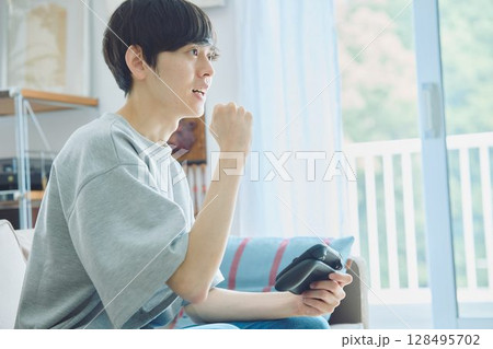 リビングでゲームをする男性 リビングでゲームをする男性 128495702
