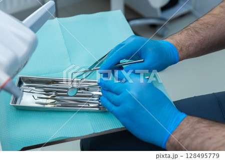 Close-Up of Dental Tools and Gloves: A Hygienic Setup for Modern Dentistry Sessions in a Well-Equipped Dental Clinic Environment Providing Patient Care and Treatment Services Close-Up of Dental Tools and Gloves: A Hygienic Setup for Modern Dentistry Sessions in a Well-Equipped Dental Clinic Environment Providing Patient Care and Treatment Services 128495779