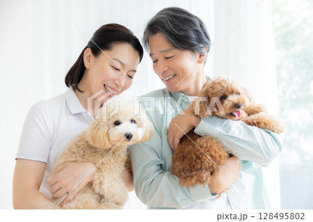 リビングで愛犬と過ごすミドル夫婦 128495802