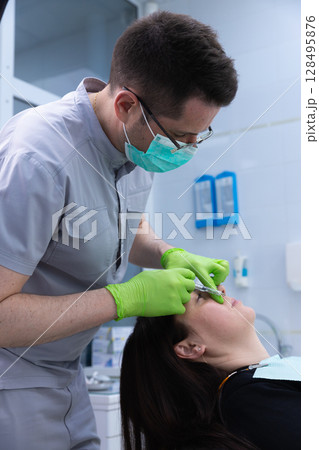 Professional Cosmetic Procedure in Progress: A Close-Up of a Skilled Practitioner Administering Treatment to a Client, Highlighting Precision and Care in a Clinical Setting 128495876