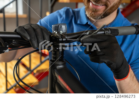 Master adjusting bike gears in modern garage with organized tools around Master adjusting bike gears in modern garage with organized tools around 128496273