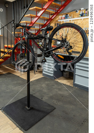 Bicycle on stand in garage prepared for mechanic work 128496368