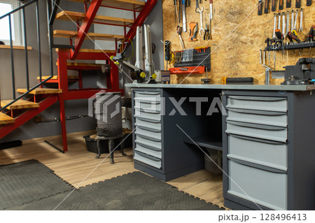 Garage interior with mechanic workspace holds neatly organized tools 128496413