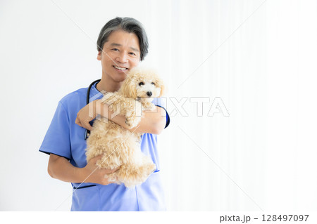 獣医 ビションプーを抱っこしている獣医師のポートレート 獣医 ビションプーを抱っこしている獣医師のポートレート 128497097