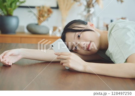 ダイニングでスマホを使う女性 128497250