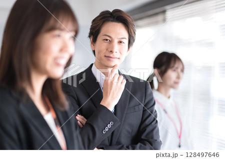 あごを触る若いスーツ姿の男性 あごを触る若いスーツ姿の男性 128497646