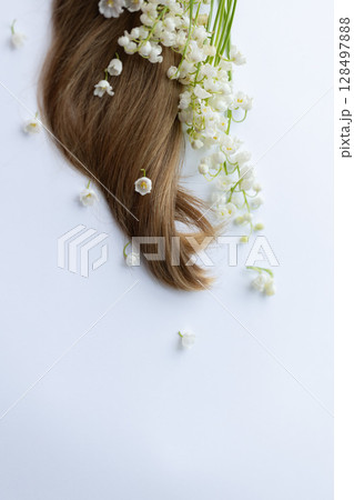 Female hair and lily of the valley flowers. On a white background. 128497888