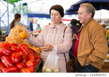 woman customers buying pepper in open-air market 128498434