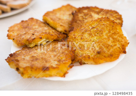 Potato pancakes with sour cream on white plate Potato pancakes with sour cream on white plate 128498435