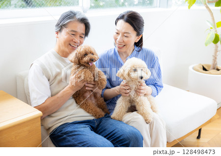 リビングで愛犬と過ごすミドル夫婦 リビングで愛犬と過ごすミドル夫婦 128498473