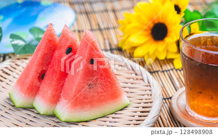 夏の風物詩 カットスイカとひまわり 128498908