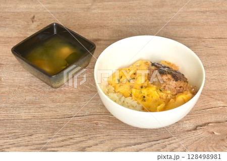 grilled hamburg pork steak and creamy egg omelets topping on rice in bowl with miso or soy sauce soup grilled hamburg pork steak and creamy egg omelets topping on rice in bowl with miso or soy sauce soup 128498981