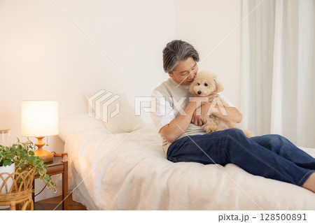 ペット　飼い主とベッドでくつろぐ犬 128500891