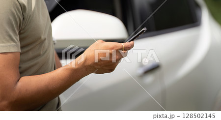 Mobile Connection. Man using smartphone while standing by his car. 128502145