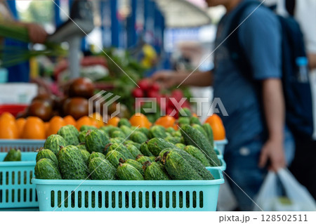 Basket of fresh cucumbers on the counter of the city market. Fresh vegetables from the field. Shoppers buying vegetables at the market. Basket of fresh cucumbers on the counter of the city market. Fresh vegetables from the field. Shoppers buying vegetables at the market. 128502511