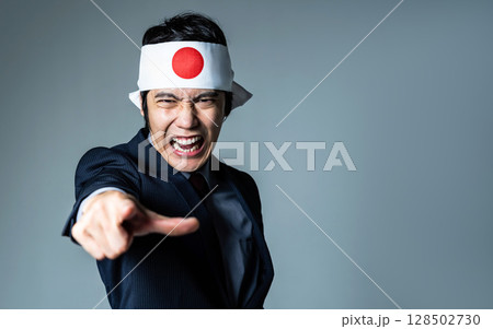 日の丸の鉢巻をつけて叫ぶ男性 128502730