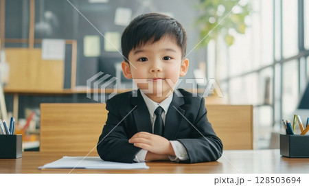 Cute Boy in Suit Sitting at Desk 128503694